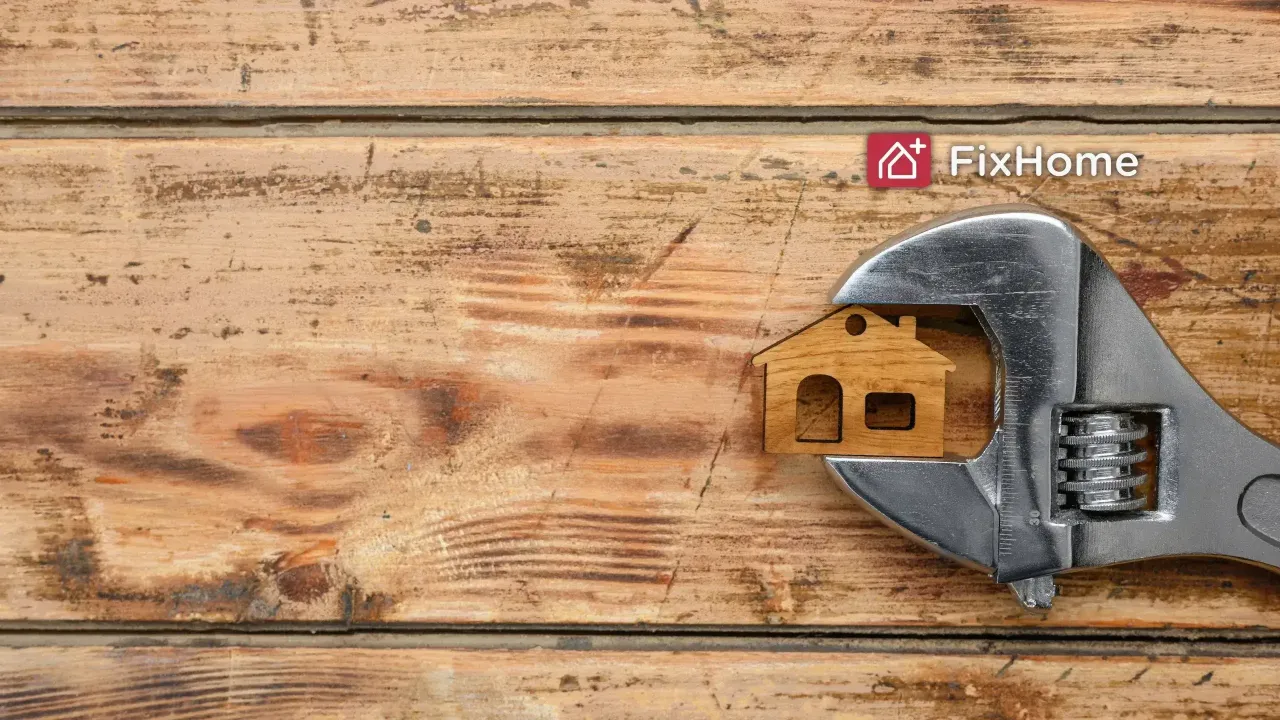 Wooden surface with crescent wrench catching the small house