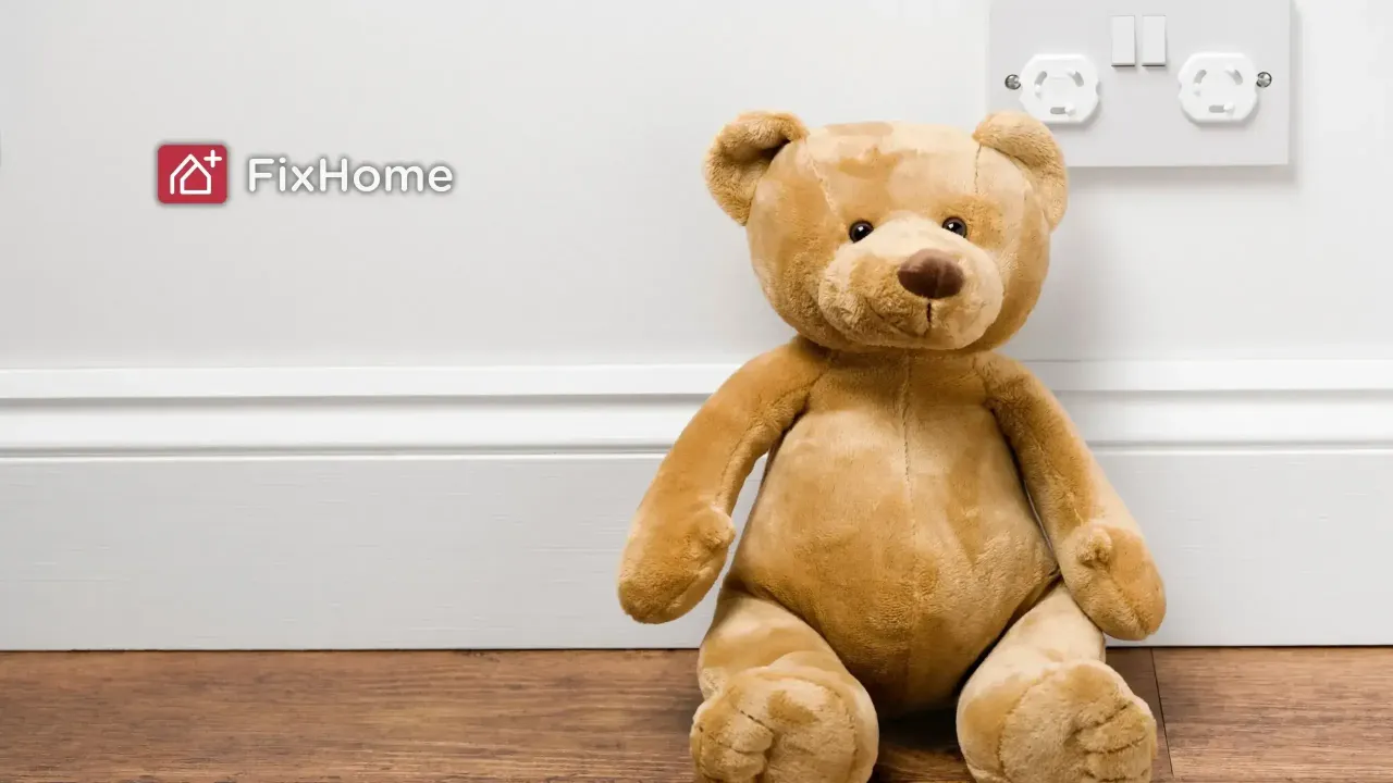 Teddy bear next to a outlet with closed protective covers