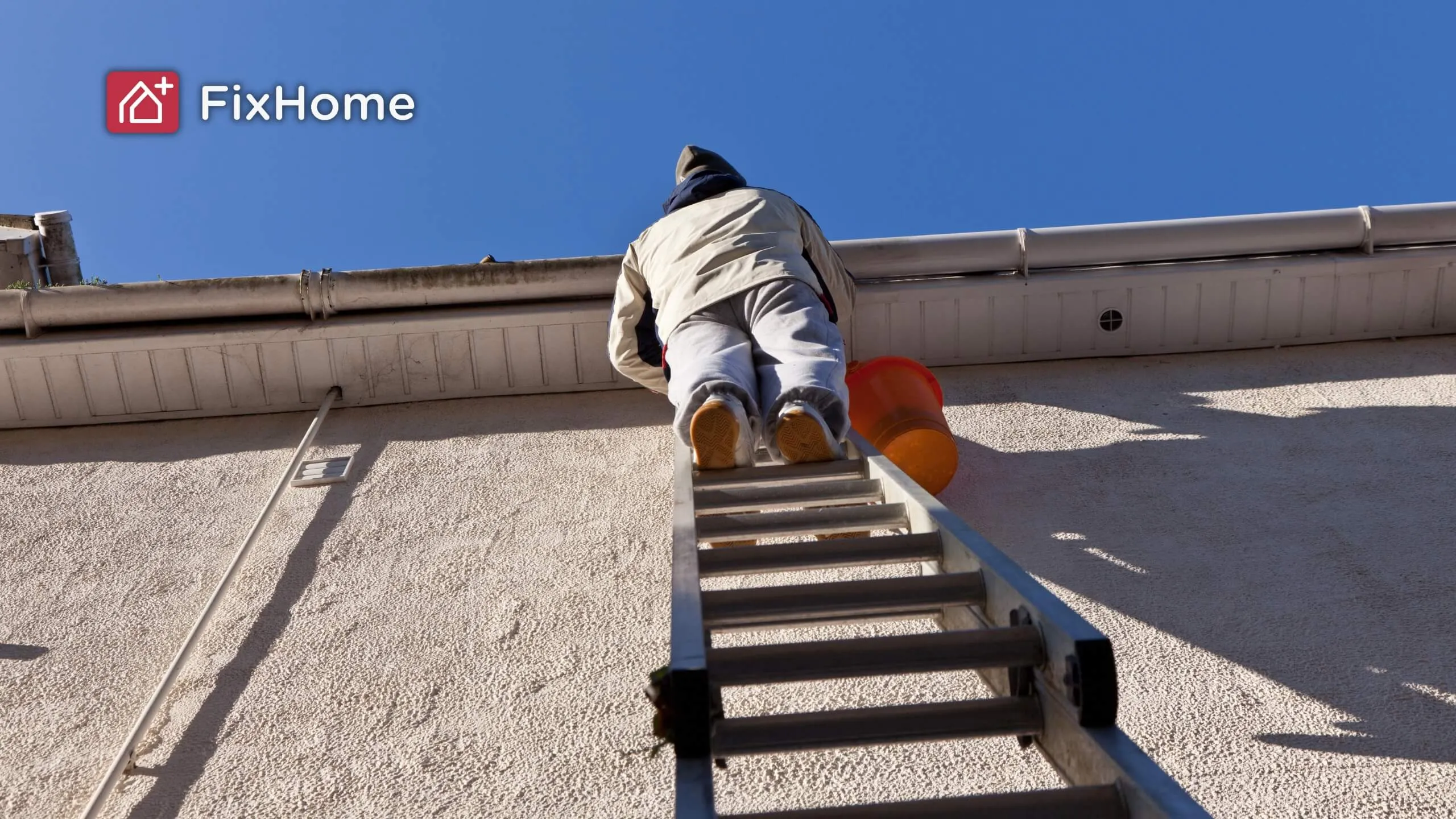Worker cleaning gutter from ladder