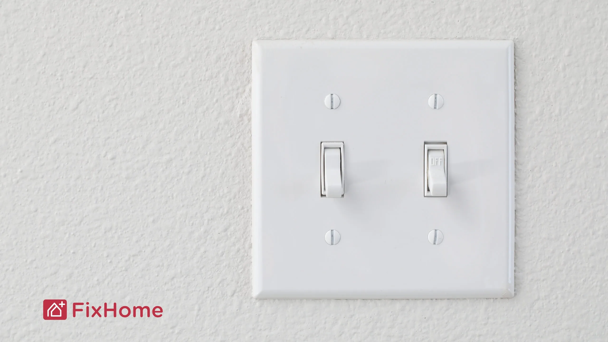 A standard white light switch mounted on a wall, showing two toggle switches