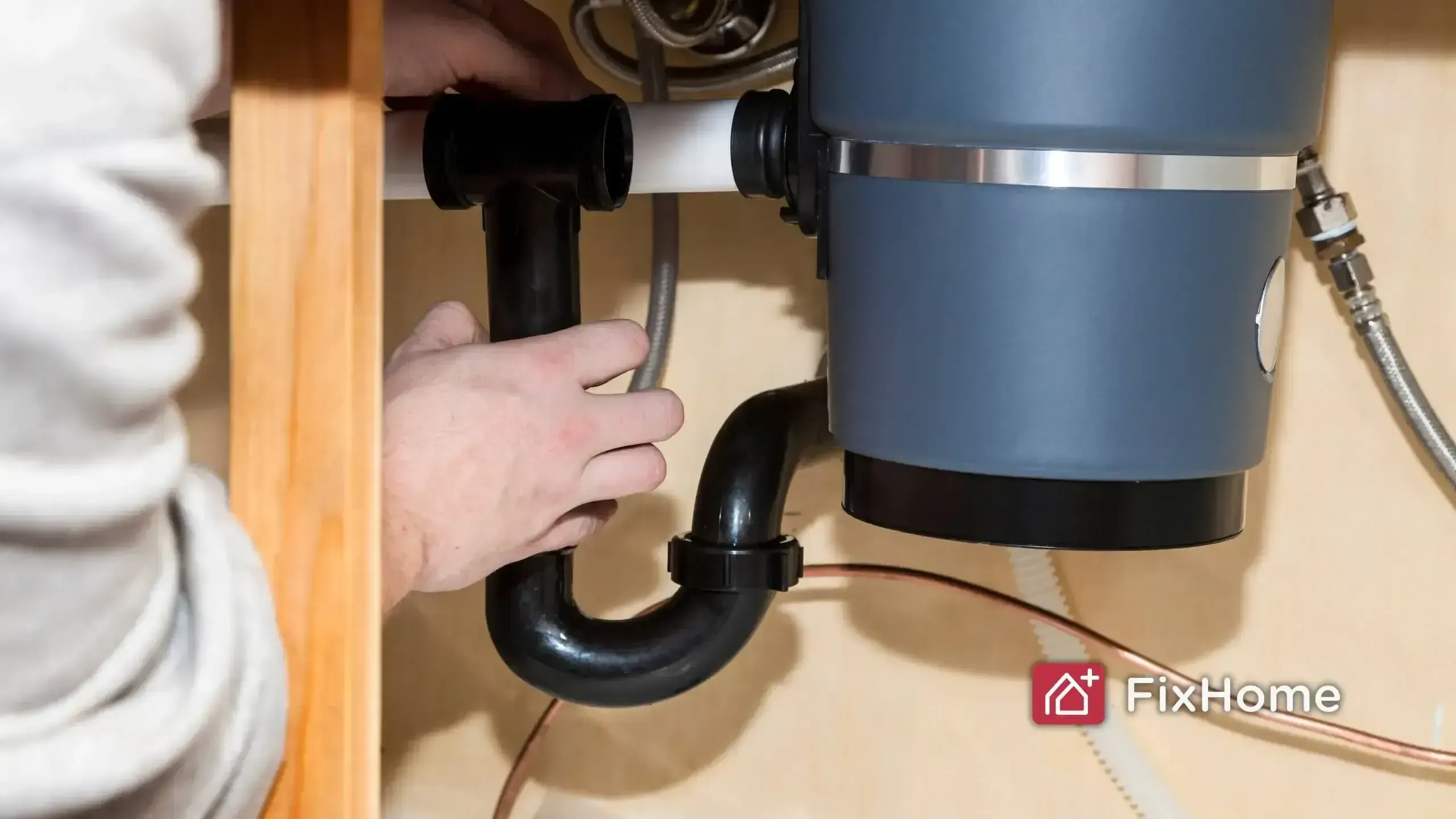 Installing a drain pipe to a garbage disposal unit.