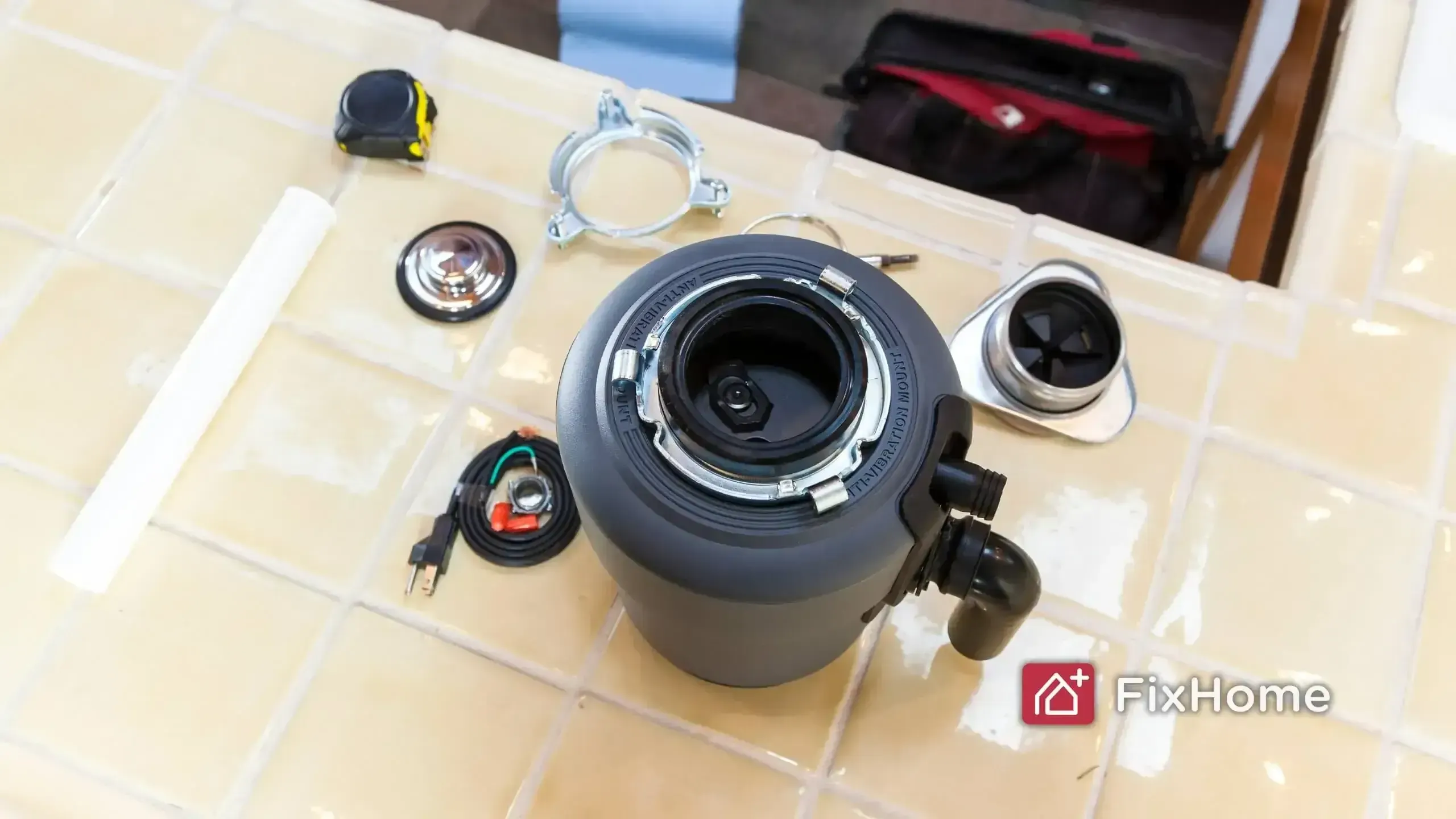 Components for installing a new garbage disposal, including the unit, flange, splash guard, wiring, and plumber's putty
