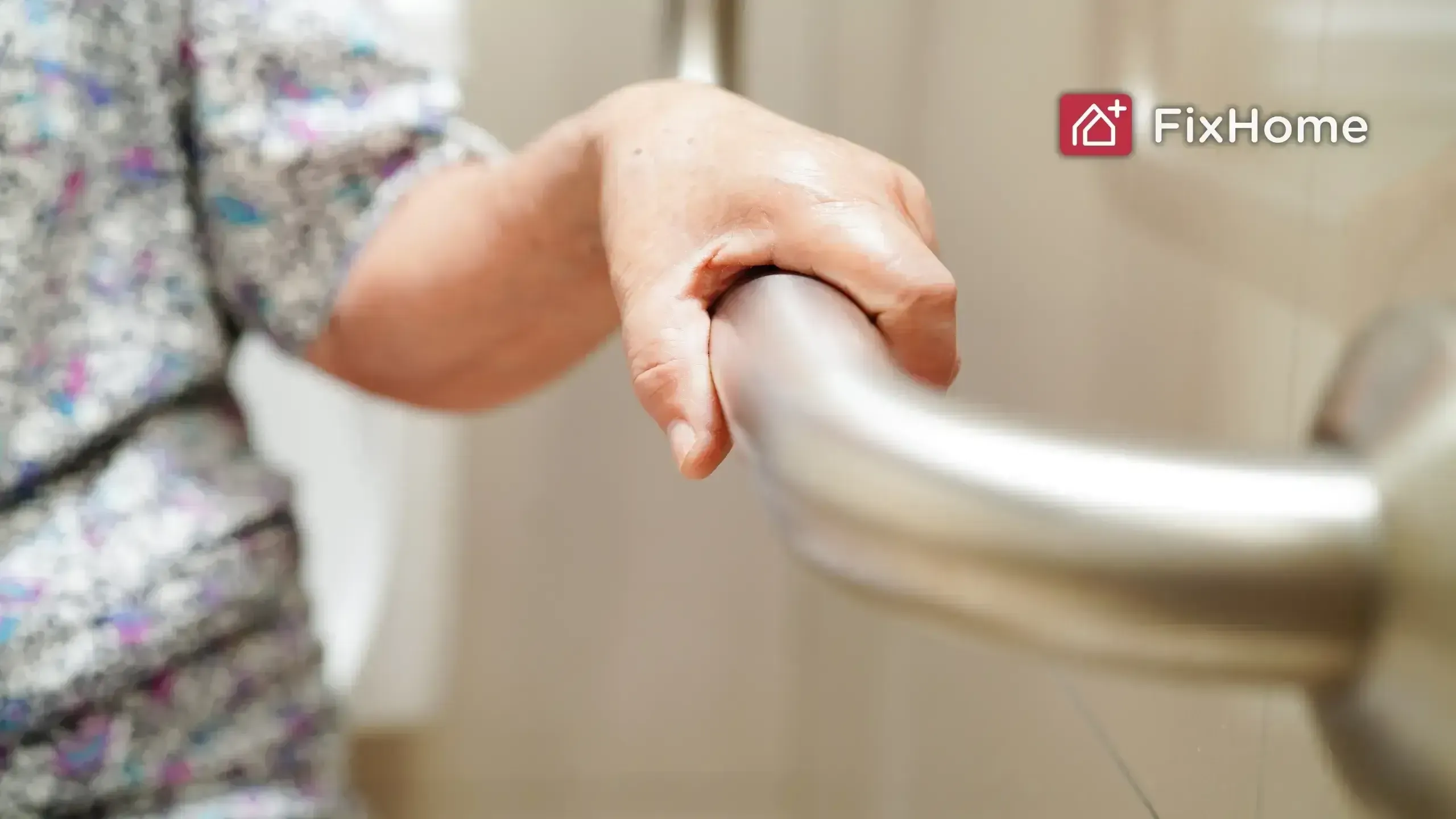 A person is holding onto the handrail of a toilet.