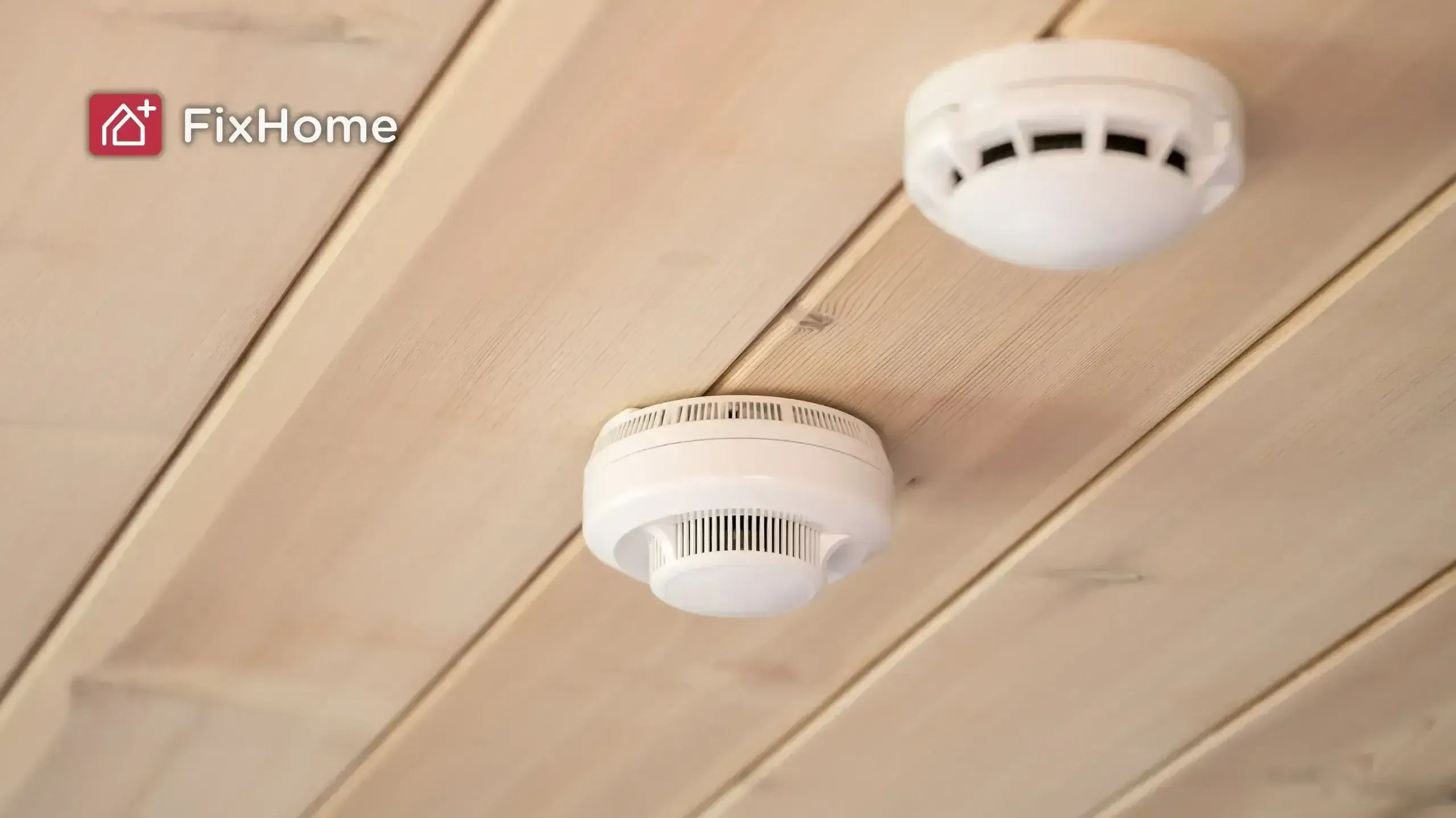 Carbon monoxide and smoke detectors mounted on the ceiling of a room