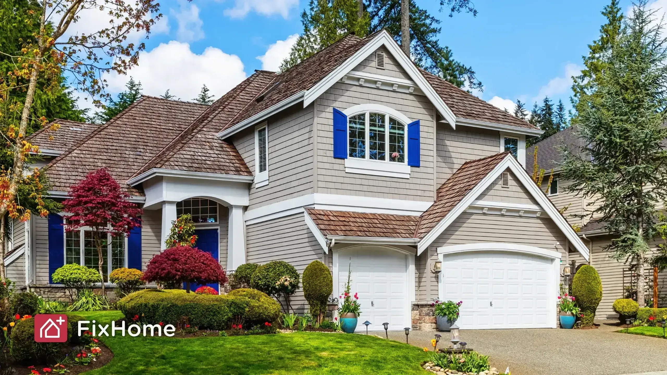 A well-maintained suburban home with gray siding, blue shutters, and a manicured garden