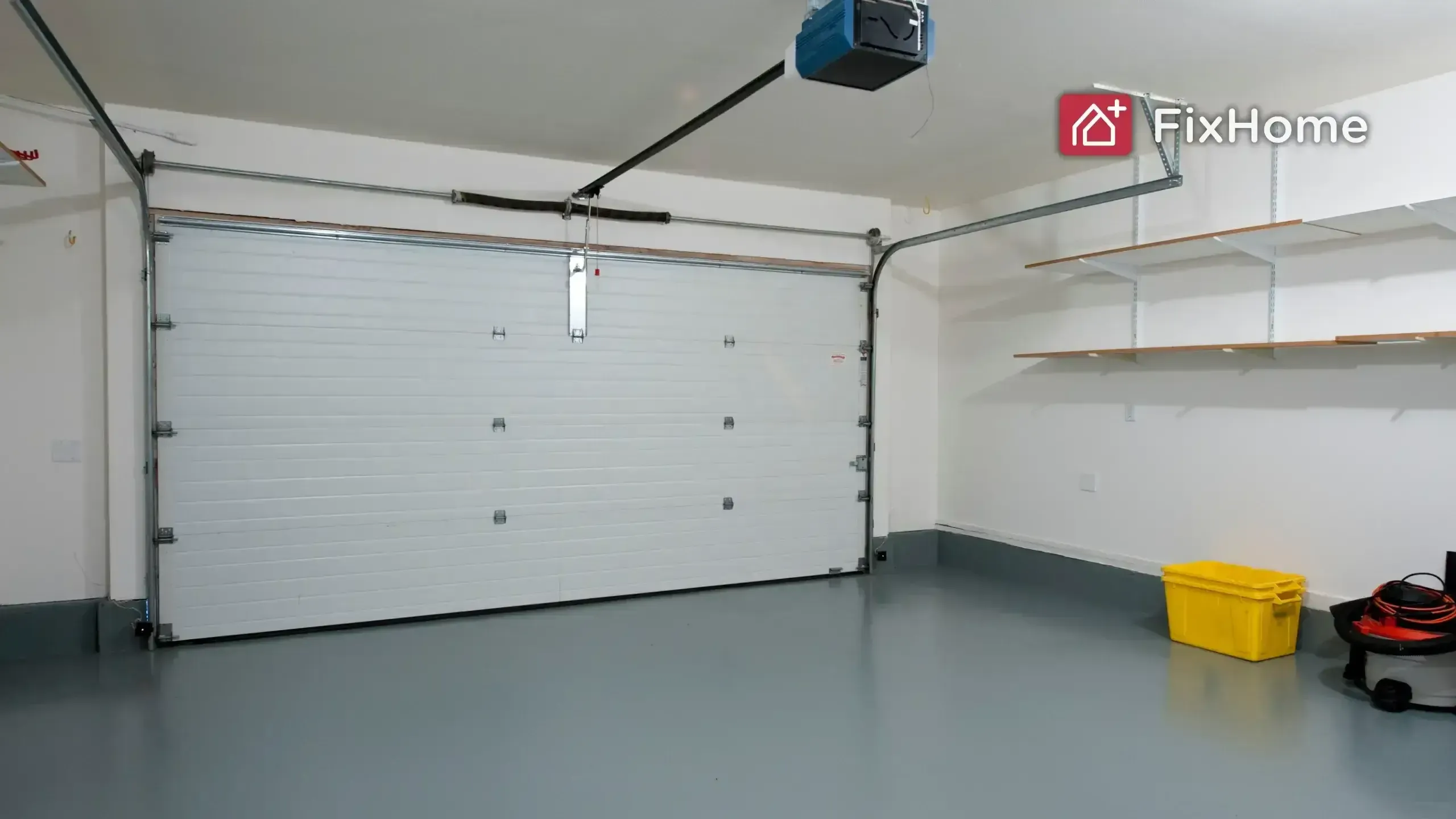 A clean garage with a white roll-up door, yellow storage bin, and shelves on the wall