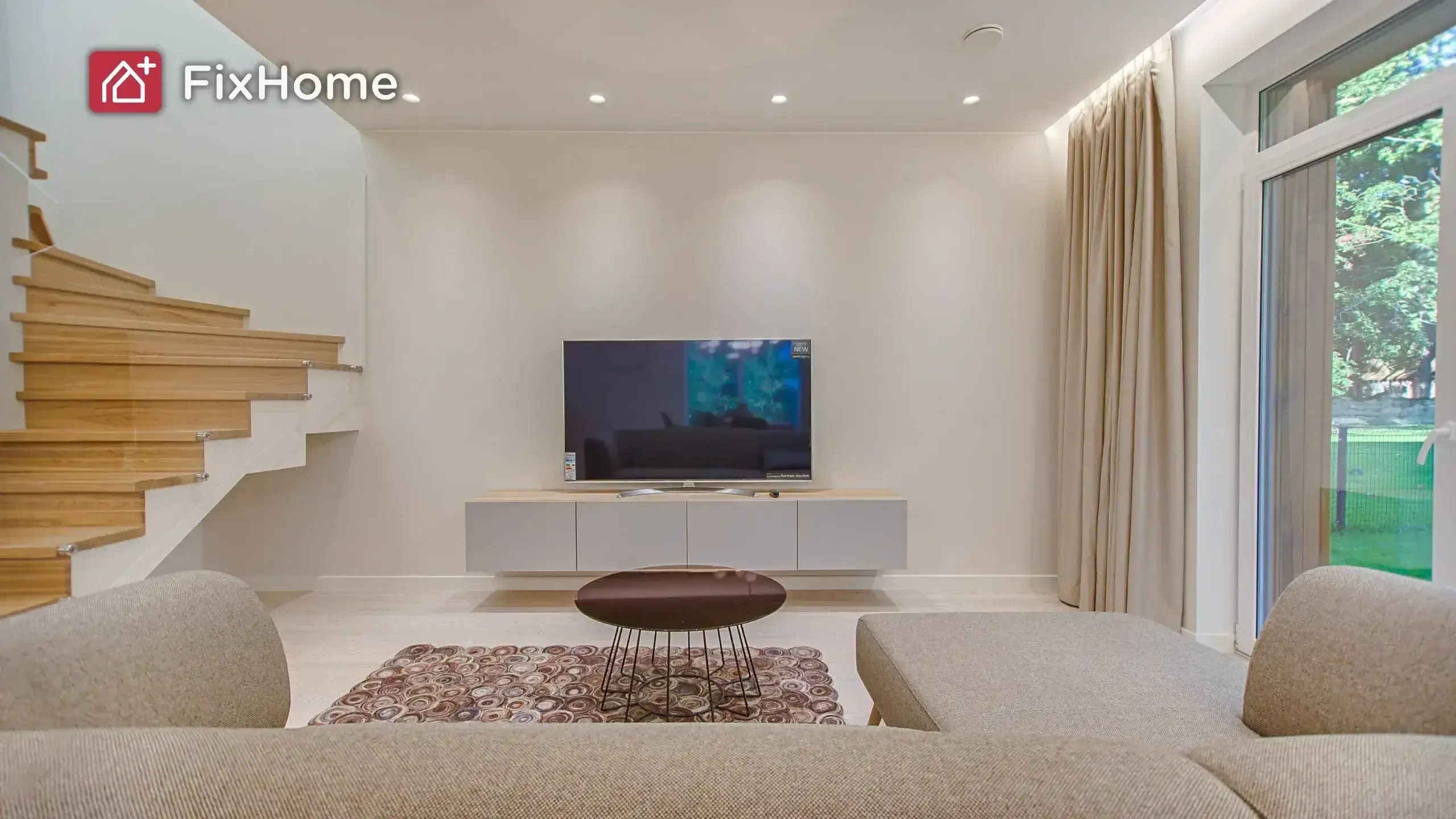 living room with a TV on a stand, a sectional sofa, and a modern wooden staircase