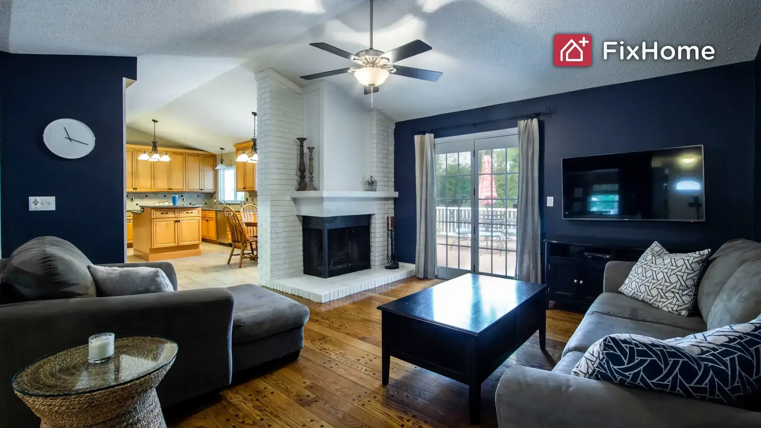 living room with dark blue walls, a TV on the wall, a white brick fireplace, a ceiling fan