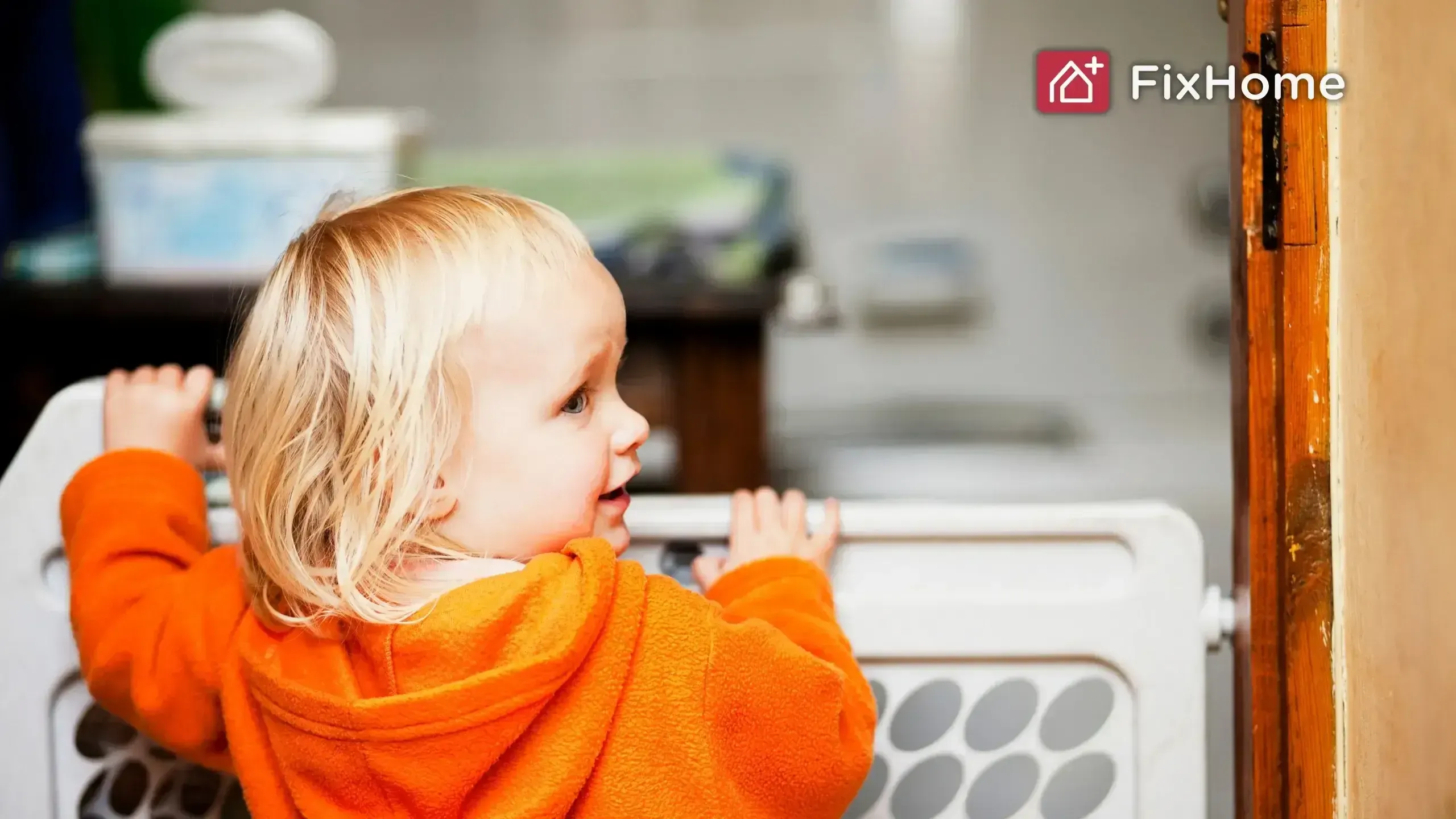 A kid in an orange jacket looking at a baby safety gate FixHomePlus