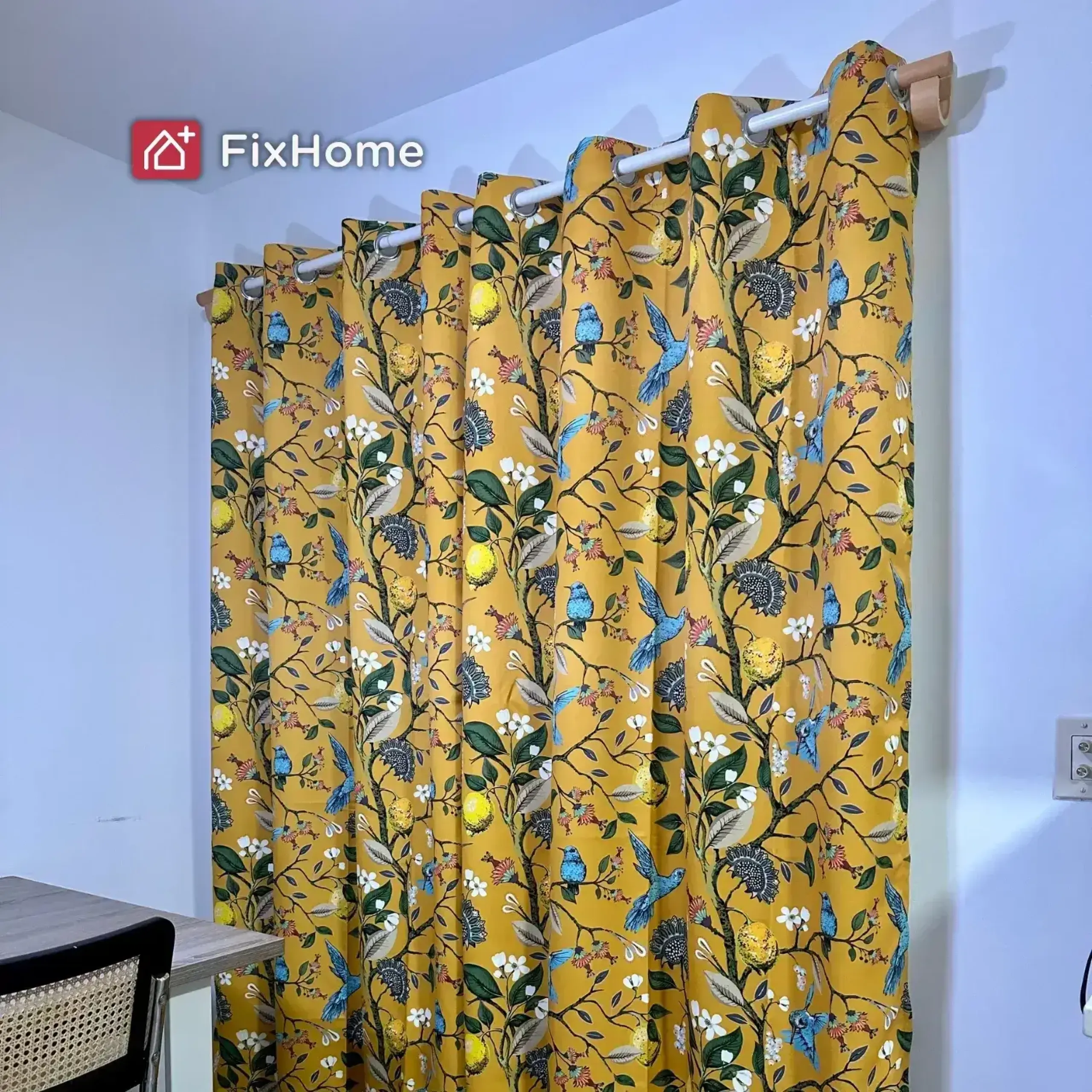 Installed Curtain rods and heavy drapes with a spring-theme print