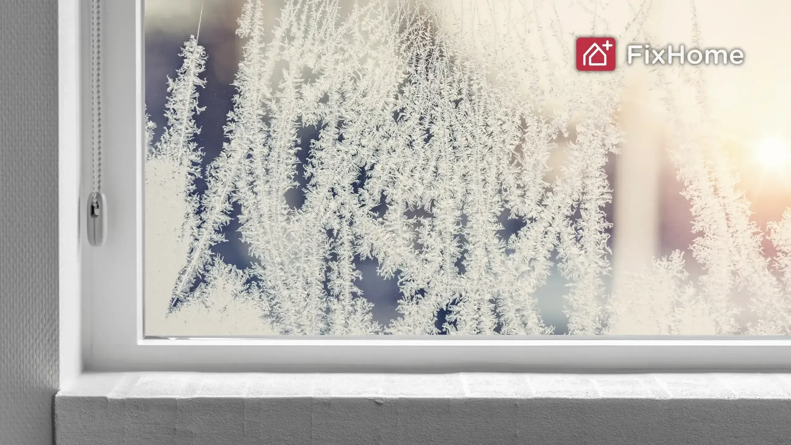 Frosty window from the inside with a white windowsill in the winter
