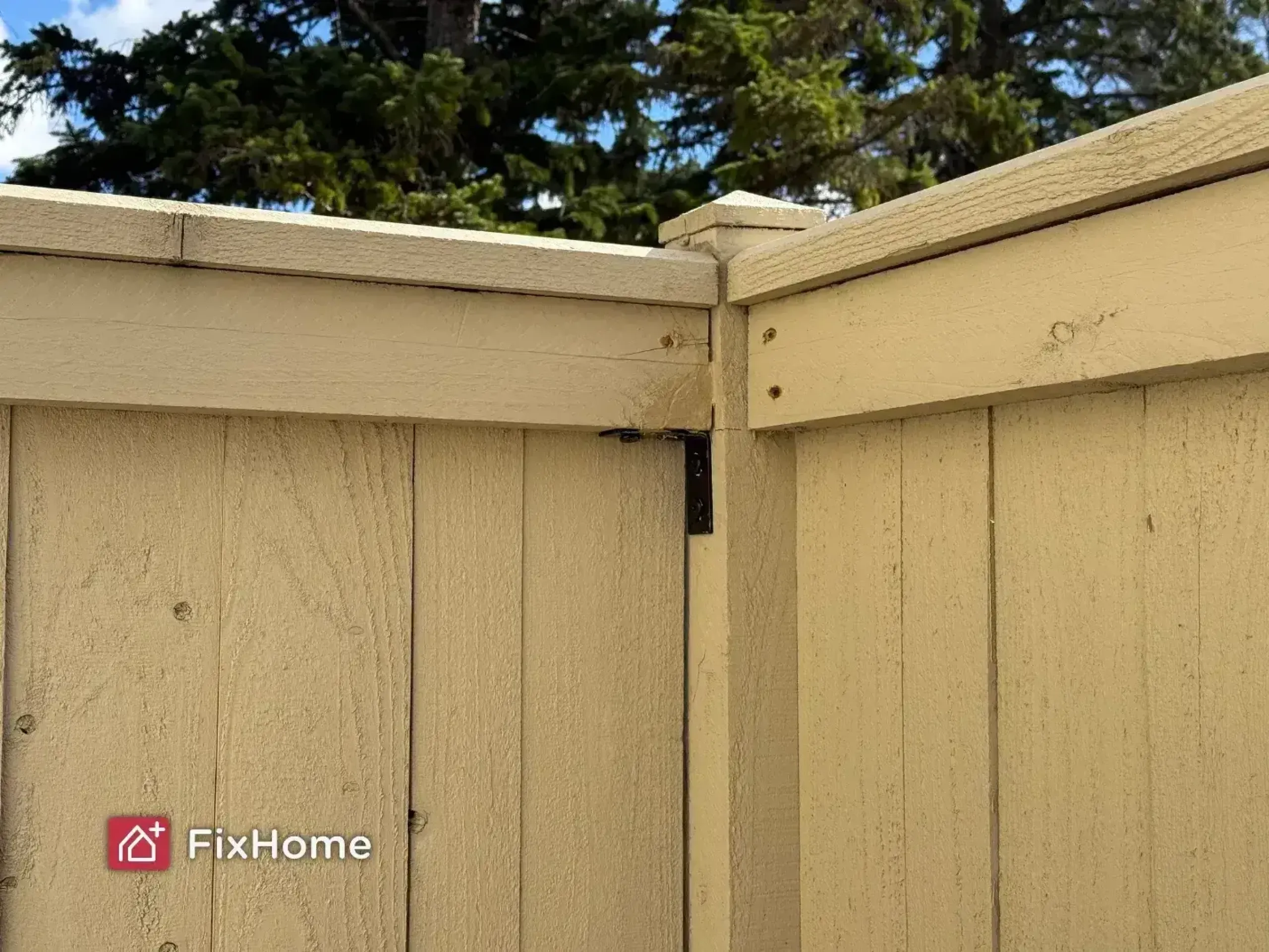 Close-up of a beige repaired wooden fence in Lake Zurich area with slanted planks and a corner joint