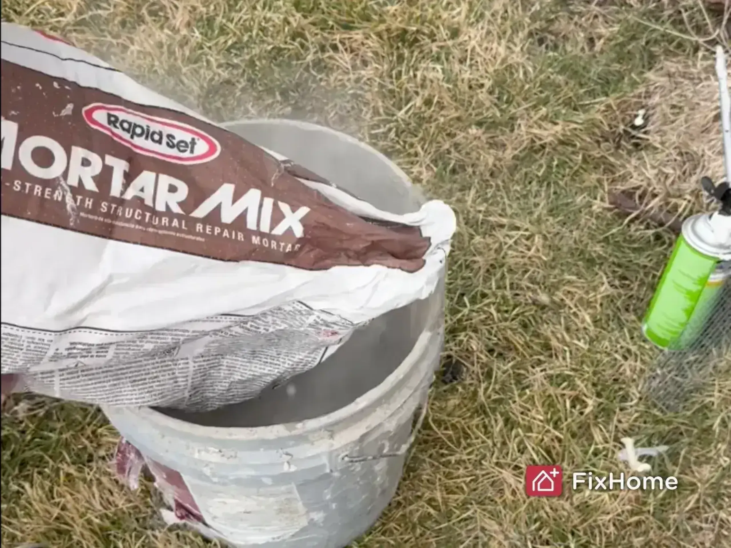 Handyman preparing mortar mix in a bucket on the grass