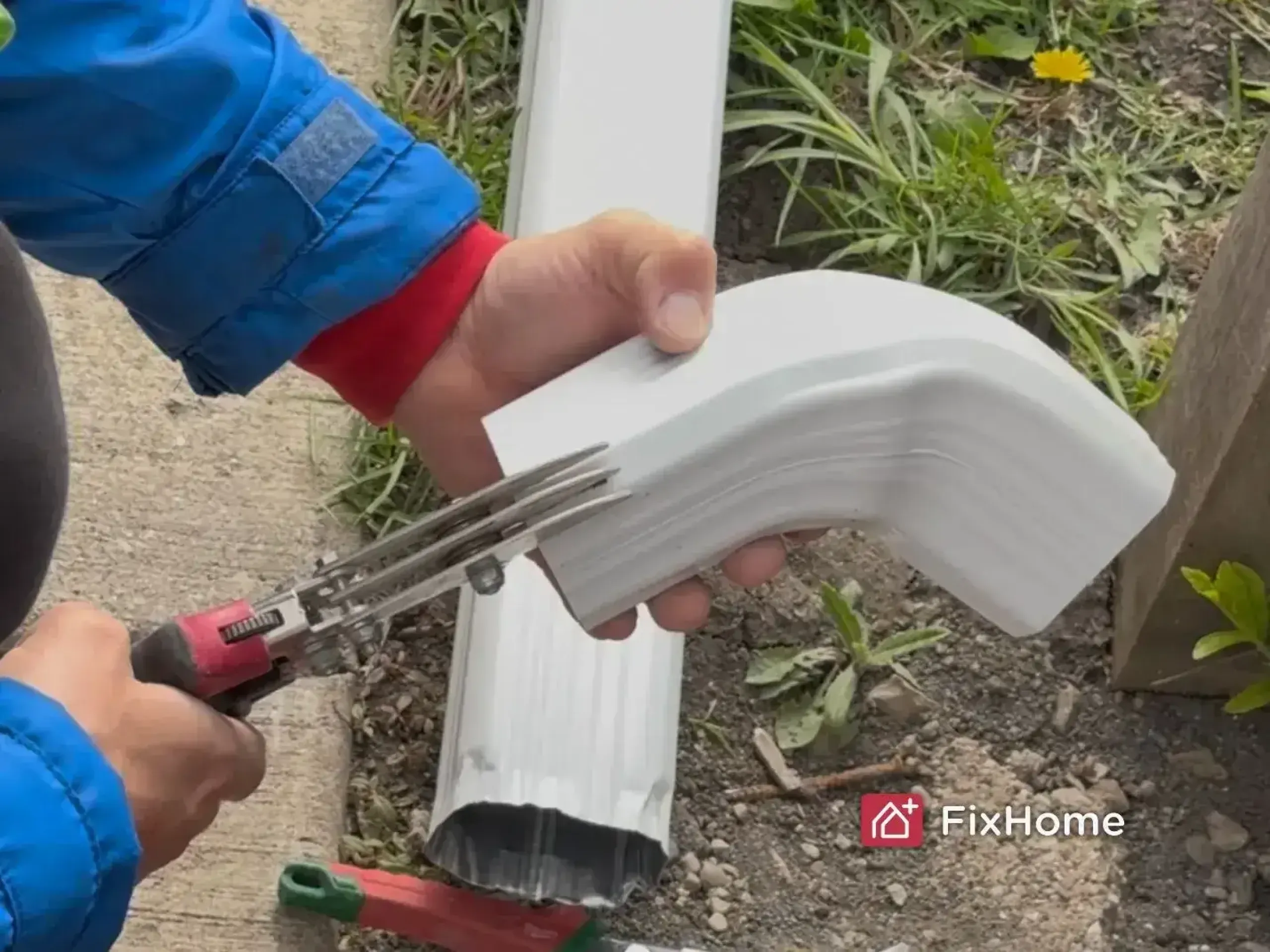 Handyman crimping a new downspout elbow during rerouting installation