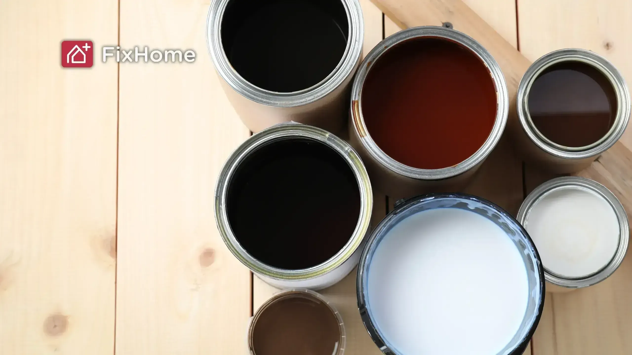 Open cans of wood stain and varnish in assorted colors on a wood deck surface
