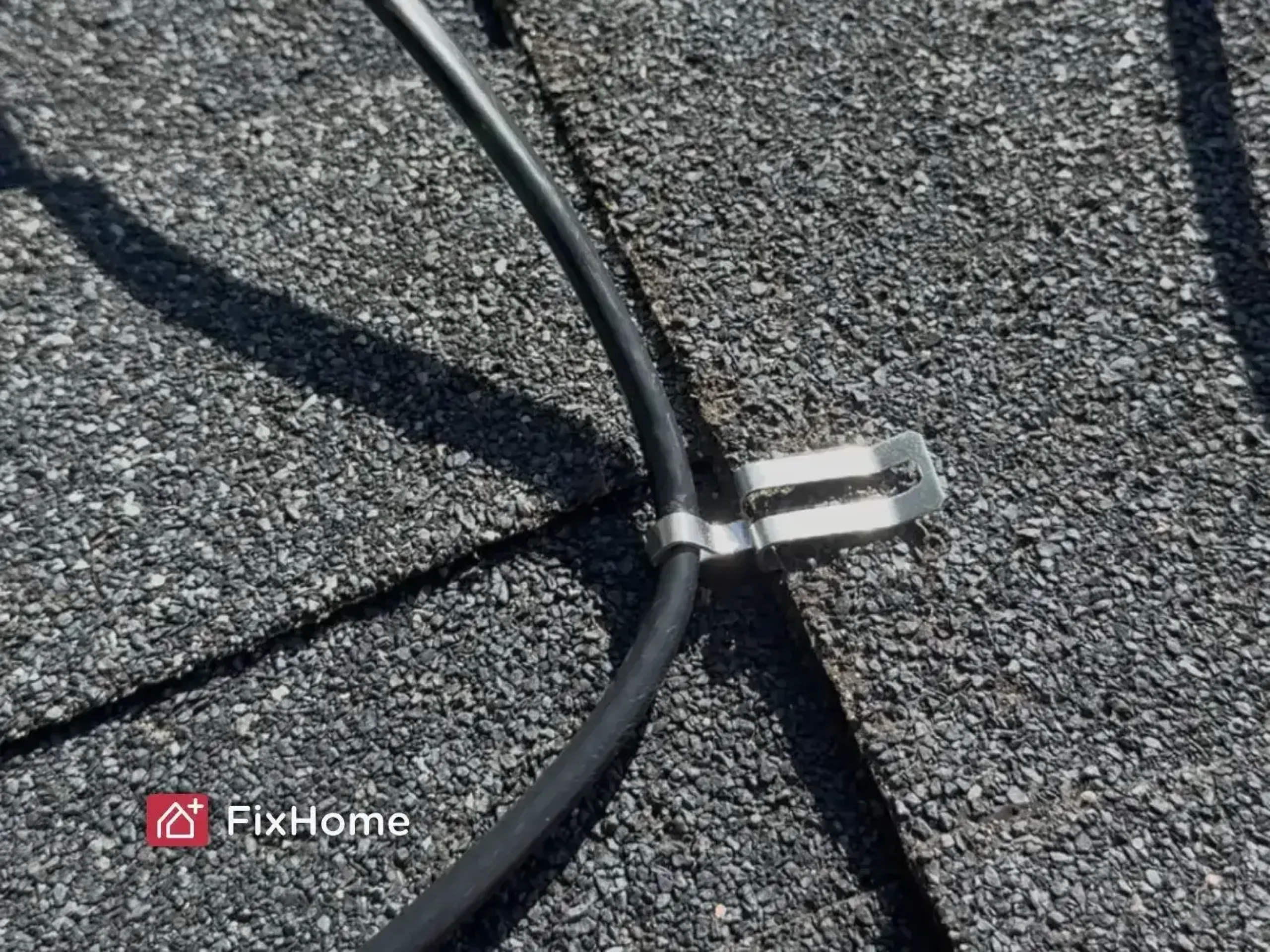 Close-up of a roof heat cable clip securing the cable to asphalt shingles in Deerfield, IL
