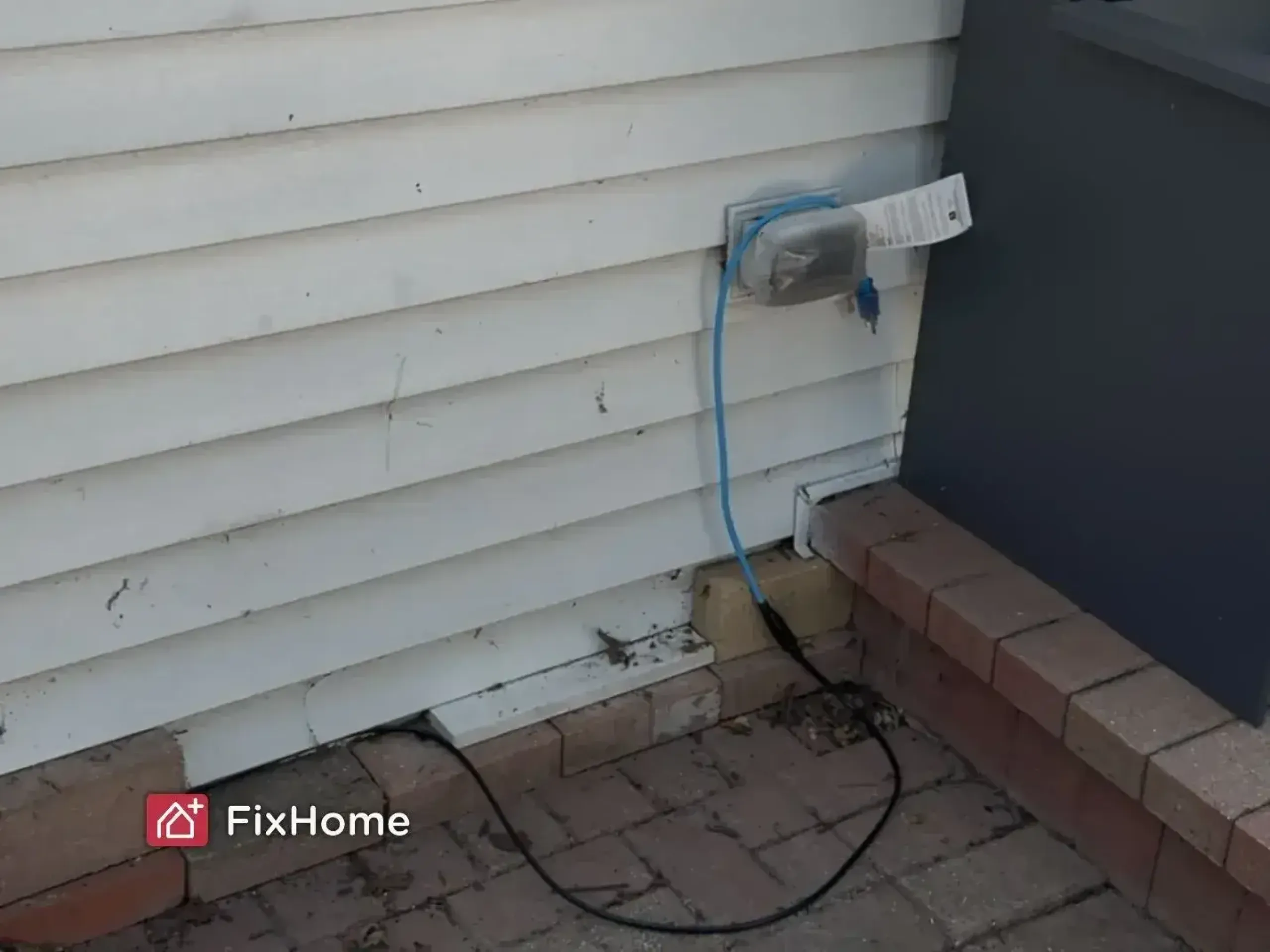 Roof heating cable installer connecting the line to an outdoor GFCI outlet in Deerfield, IL