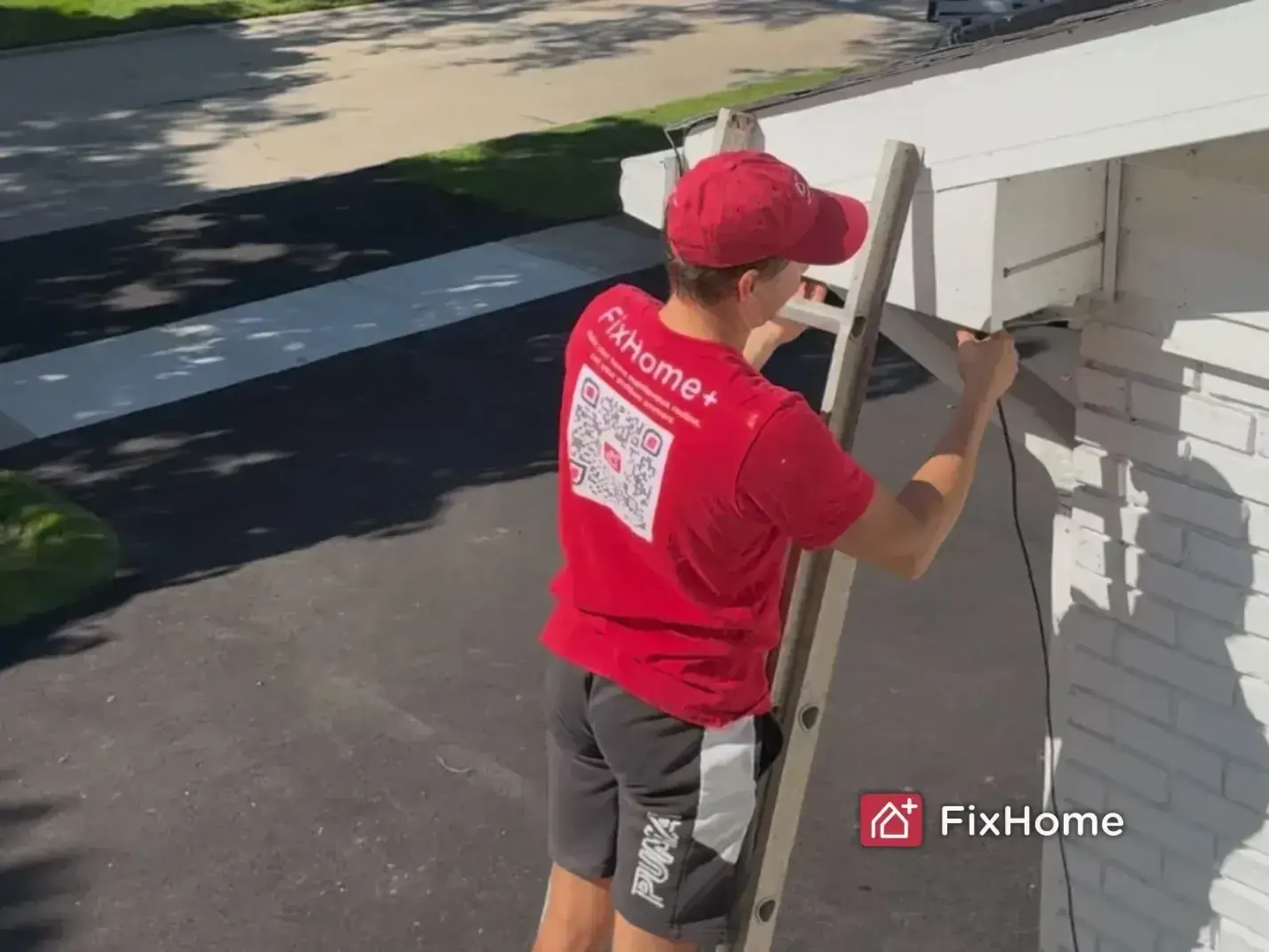 FixHome+ handyman securing the roof heating cable line from a ladder in Deerfield, IL