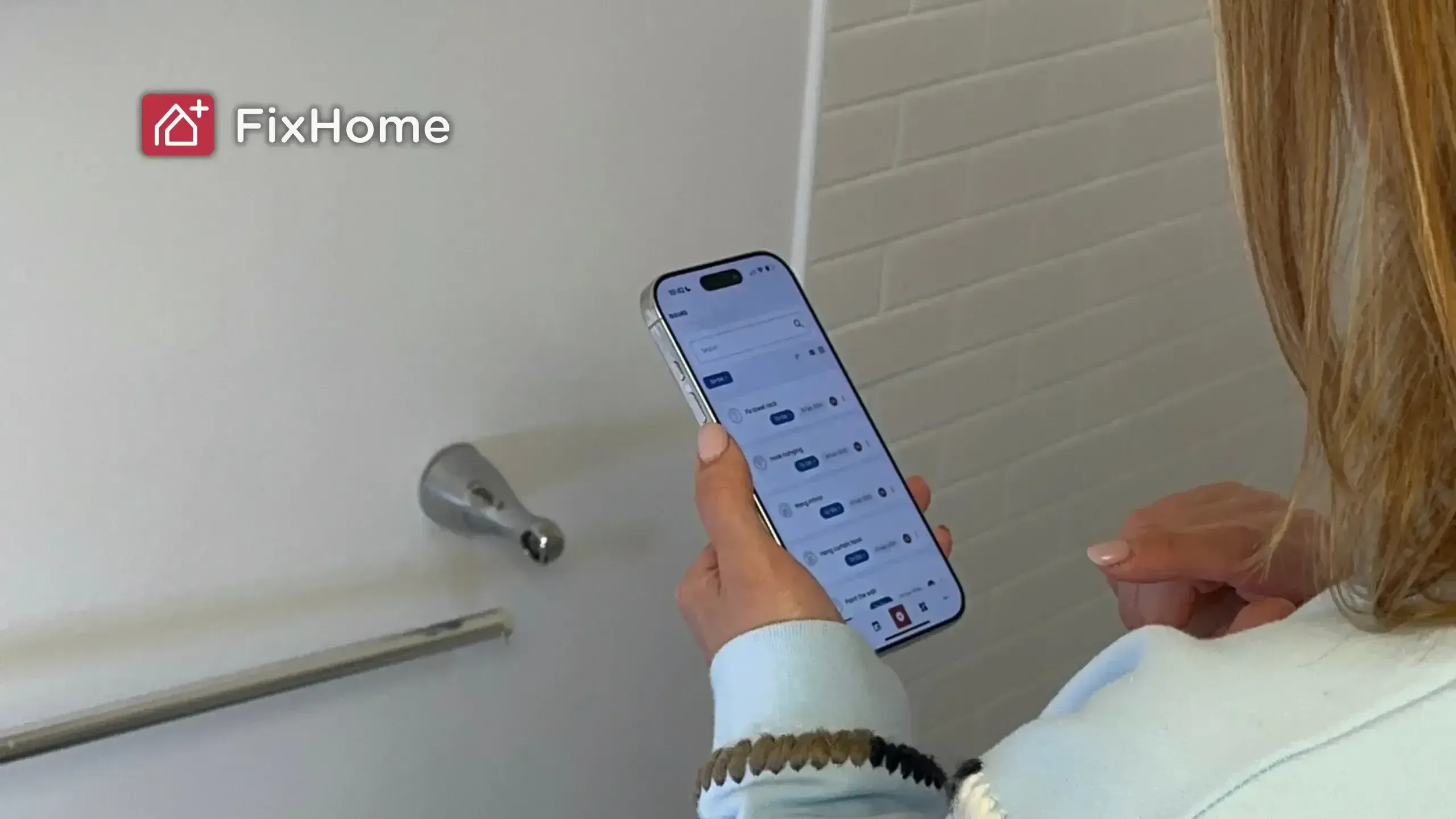Person holding phone add a task into FixHomPlus app to-do list close to broken towel bar