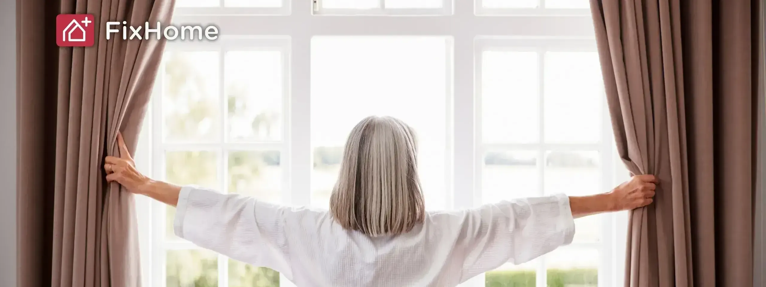 An old woman with silver hair opens the curtains in a bright room