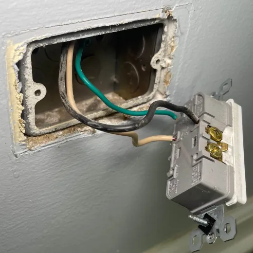 Old wall outlet with exposed wires
