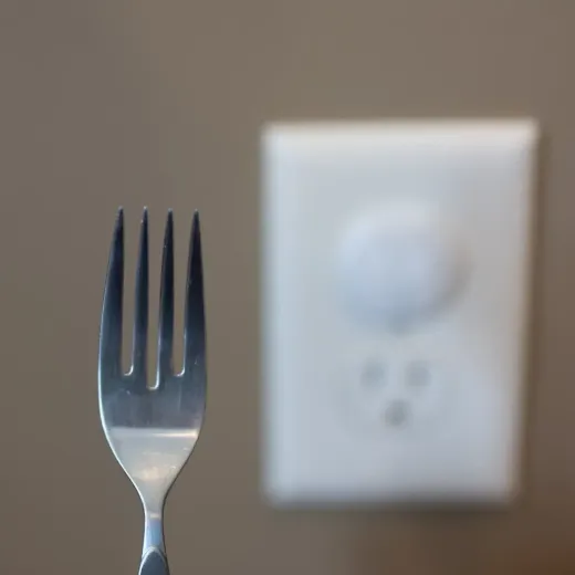 A fork in front of a blured wall outlet FixHomePlus