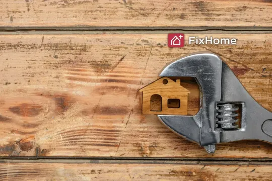 Wooden surface with crescent wrench catching the small house