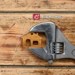 Wooden surface with crescent wrench catching the small house