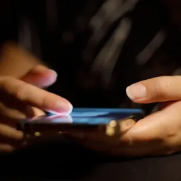 Female hand with phone in the dark space